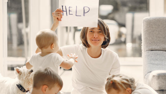 Mother holding help sign surrounded by small children