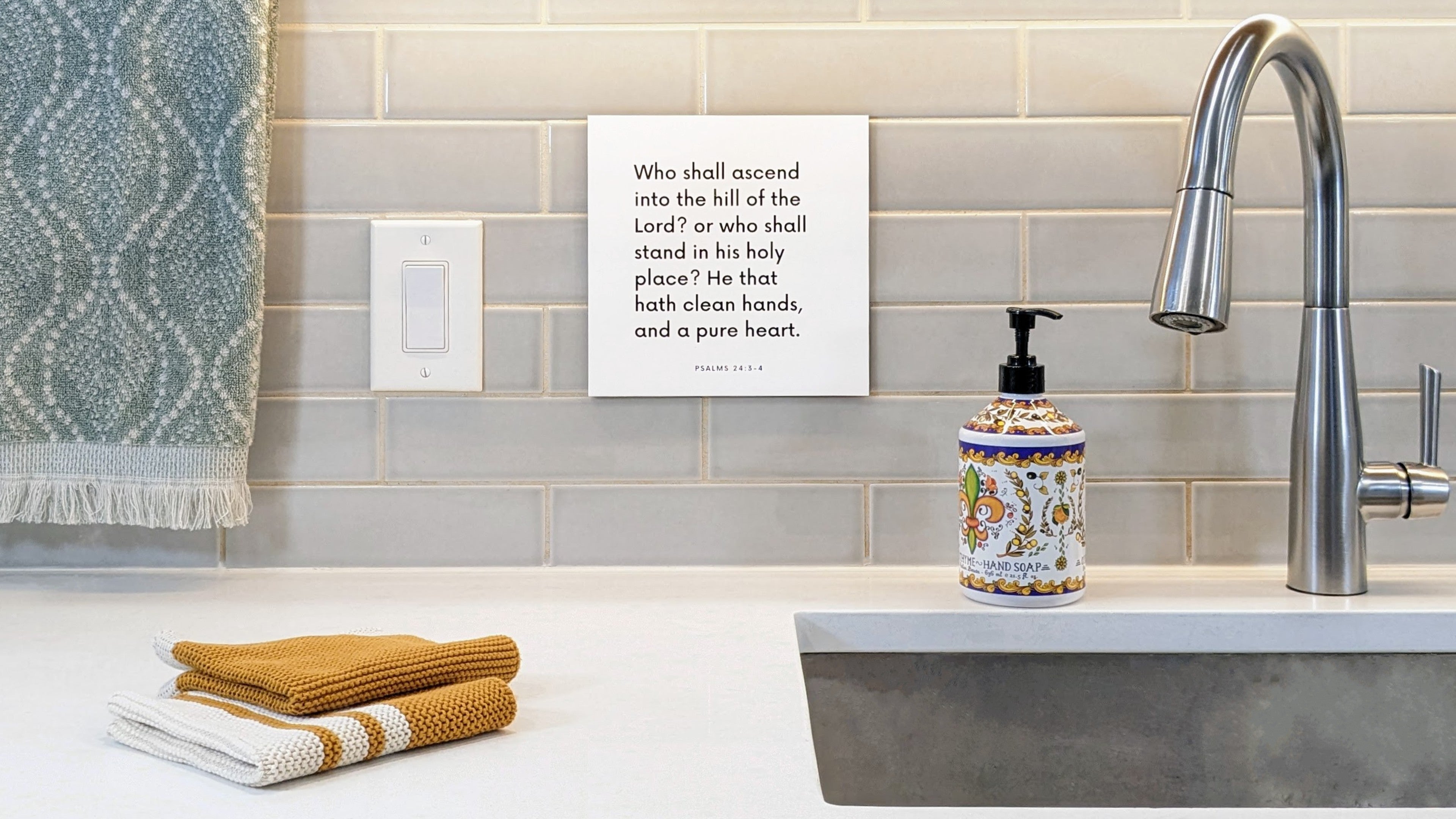 Scripture tile mounted on the wall next to a sink